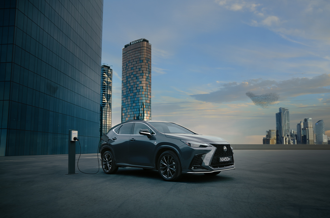 NX 450h+ parked on a rooftop with city skyline in background. 