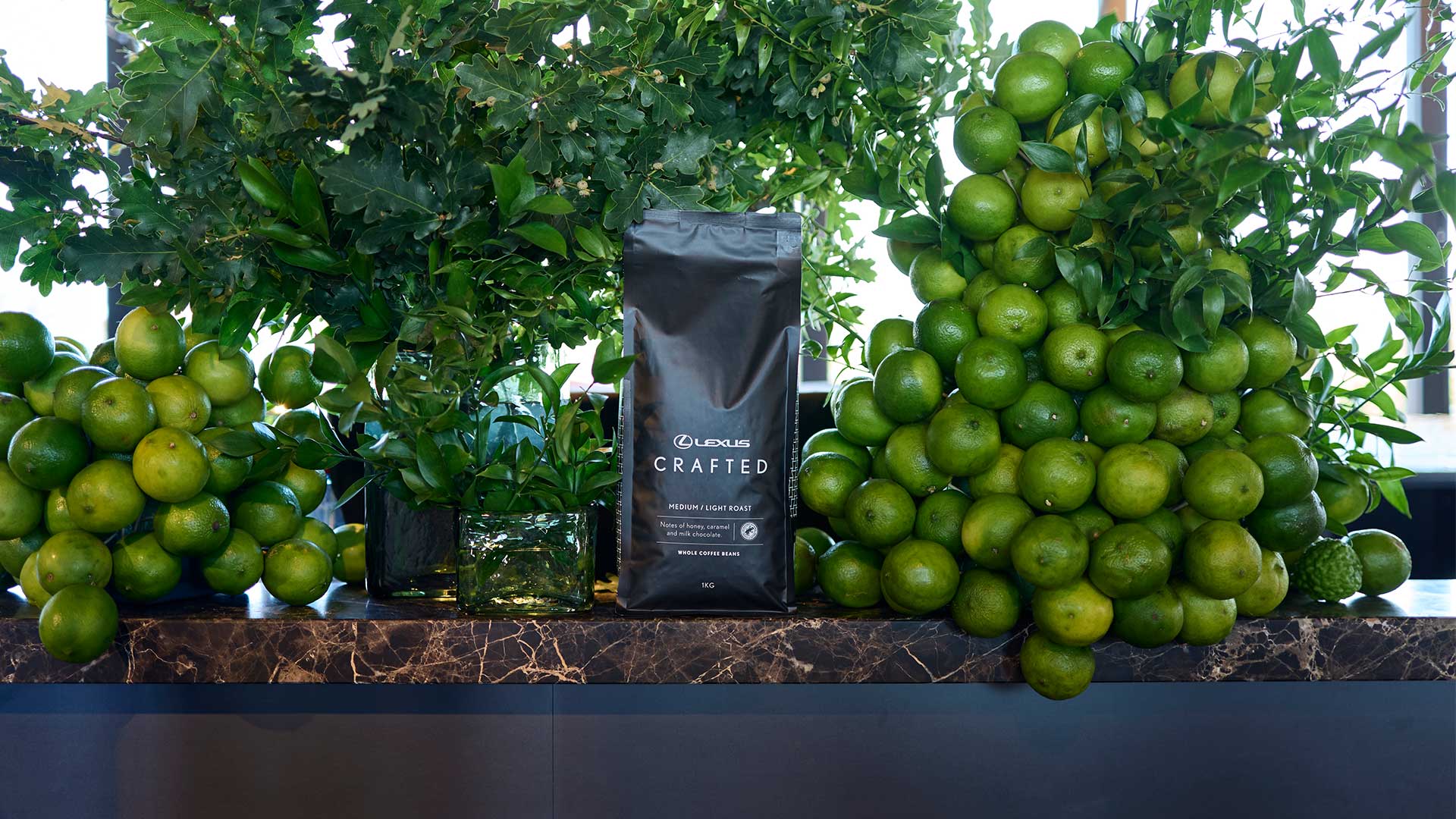 A bag of Lexus coffee beans next to a pile of limes